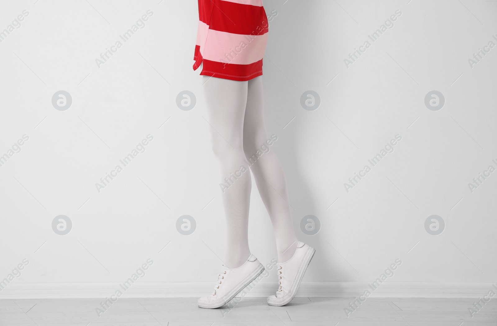 Photo of Woman wearing tights near white wall, closeup