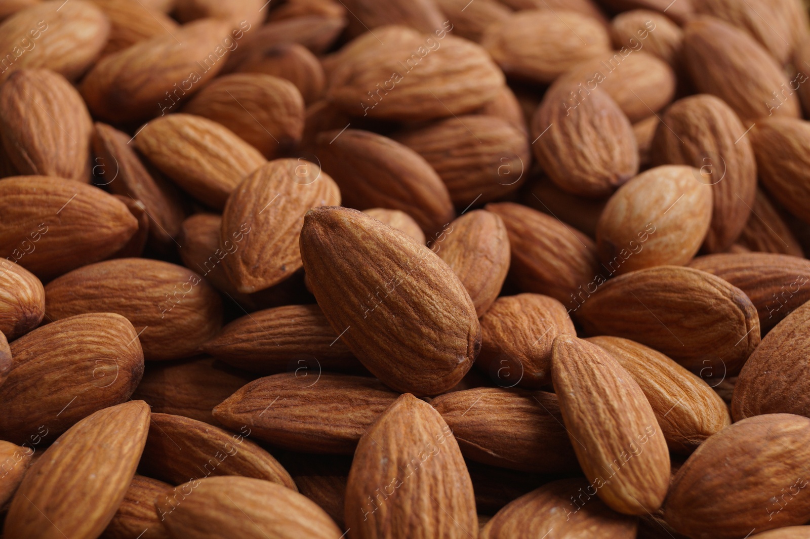 Photo of Pile of delicious raw ripe almonds, closeup