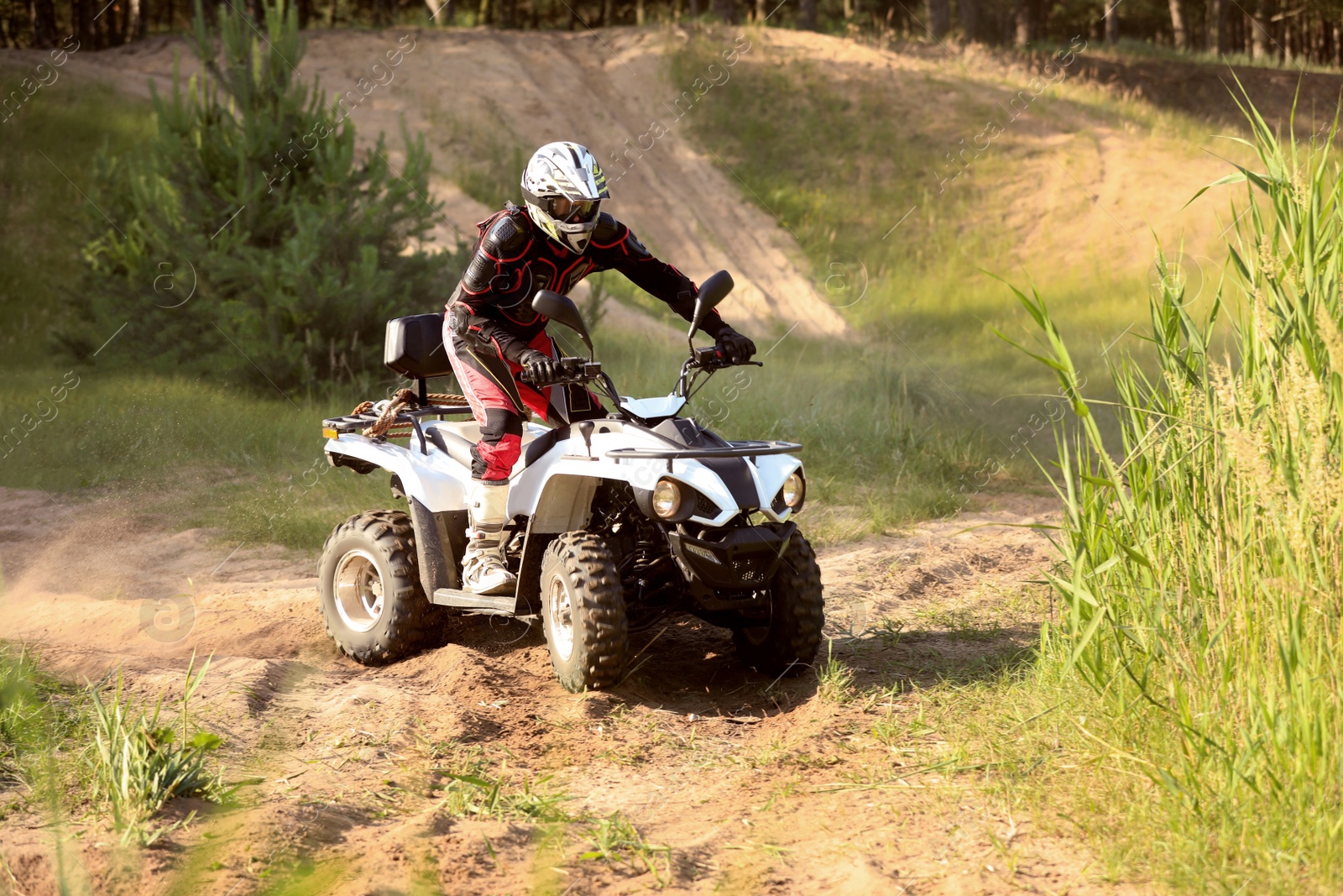 Photo of Man driving modern quad bike on sandy road. Extreme sport