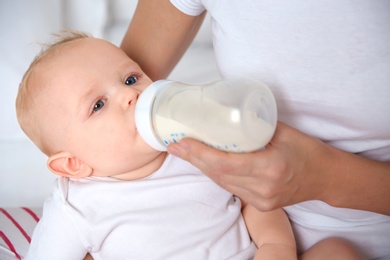 Lovely mother feeding her baby from bottle, closeup