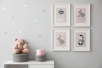 Photo of Stylish baby room interior with chest of drawers and cute pictures on wall