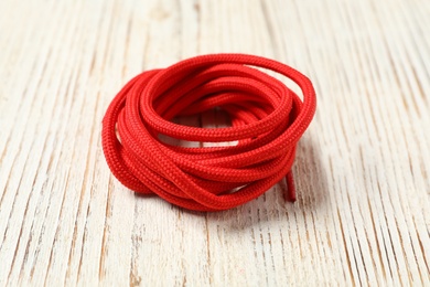 Photo of Red shoelaces on white wooden background. Stylish accessory