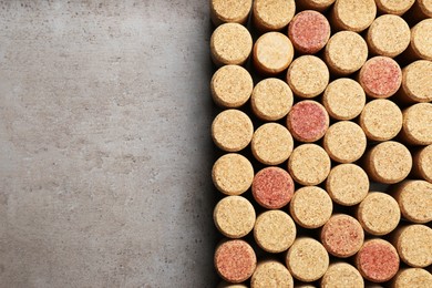 Flat lay composition with many corks of wine bottles on grey table. Space for text