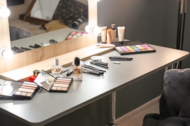 Bottles of perfume and makeup products on dressing table