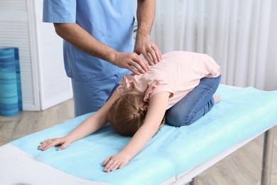 Photo of Orthopedist examining child's back in clinic, closeup. Scoliosis treatment
