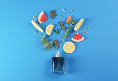 Flat lay composition with bottle of perfume on blue background
