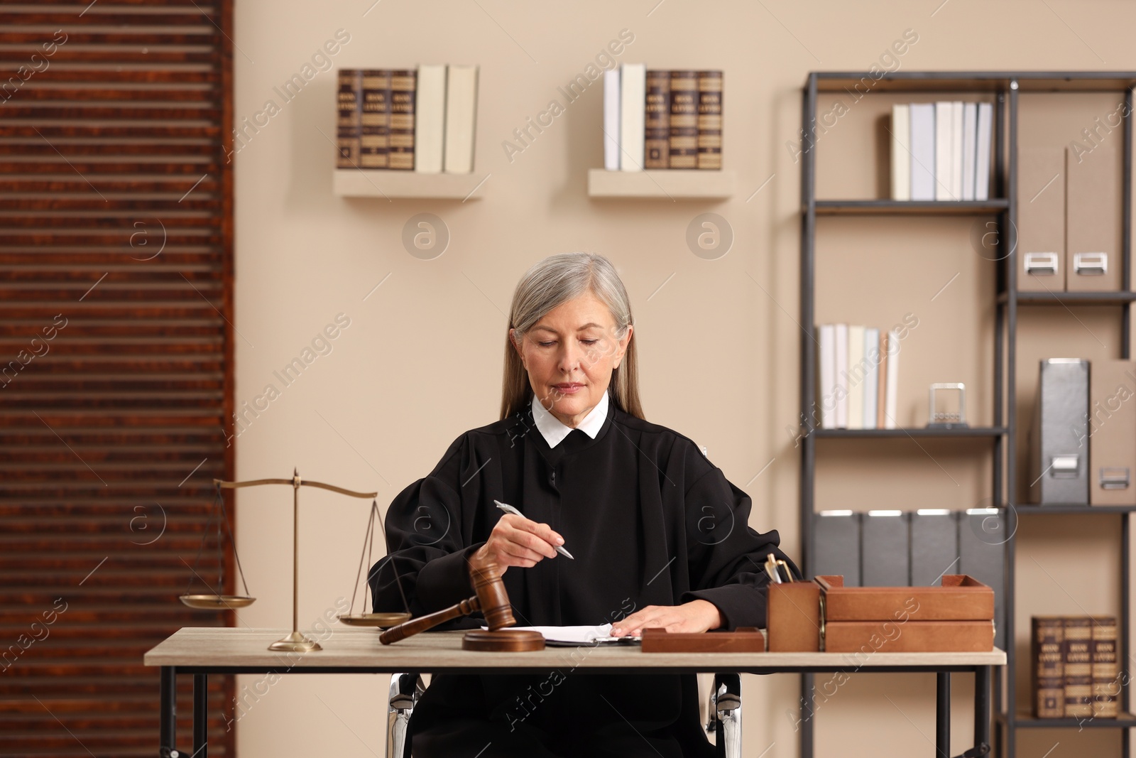 Photo of Judge working with document at table indoors