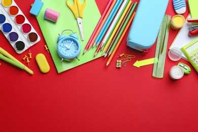 Photo of Bright school stationery on red background, flat lay. Space for text