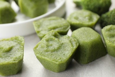 Photo of Frozen broccoli puree cubes on table, closeup