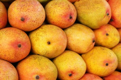 Photo of Delicious ripe yellow mangoes as background, top view
