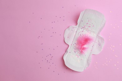 Photo of Menstrual pad and confetti on pink background, top view. Space for text