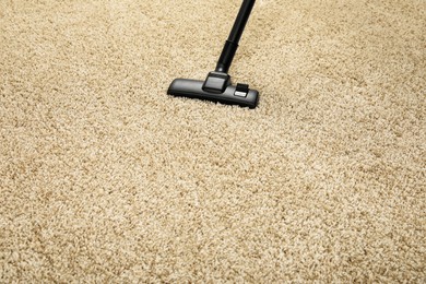 Removing dirt from beige carpet with modern vacuum cleaner. Space for text