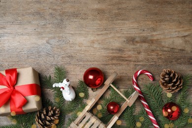 Christmas greeting card with space for text. Flat lay composition of fir tree branches and festive decor on wooden background