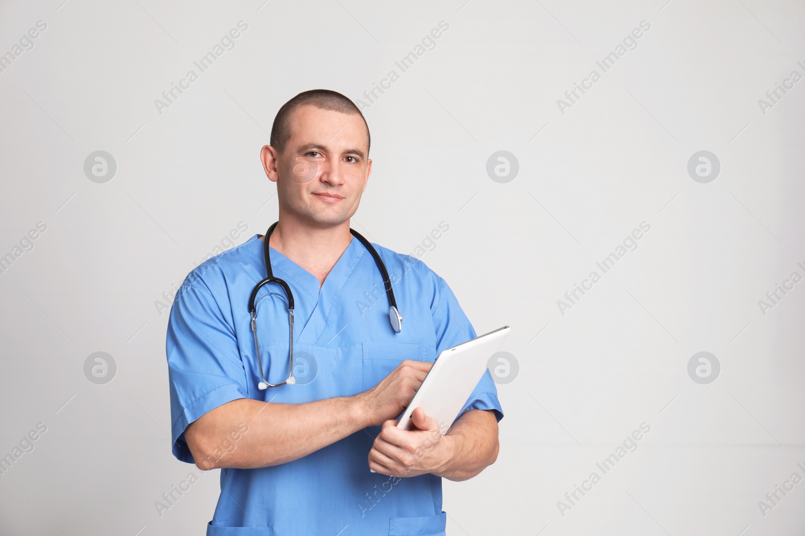 Photo of Portrait of medical assistant with stethoscope and tablet on color background. Space for text