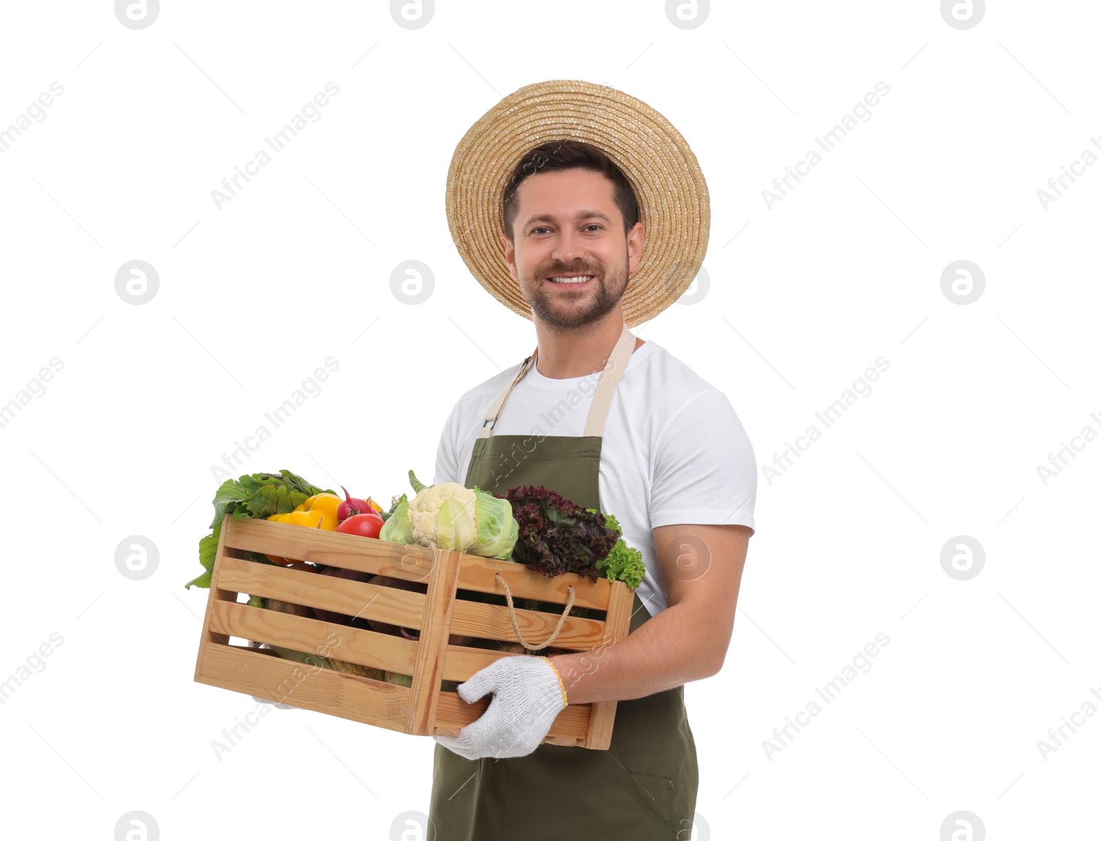 Photo of Harvesting season. Happy farmer holding wooden crate with vegetables on white background
