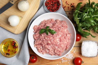 Raw chicken minced meat and ingredients on wooden table, flat lay