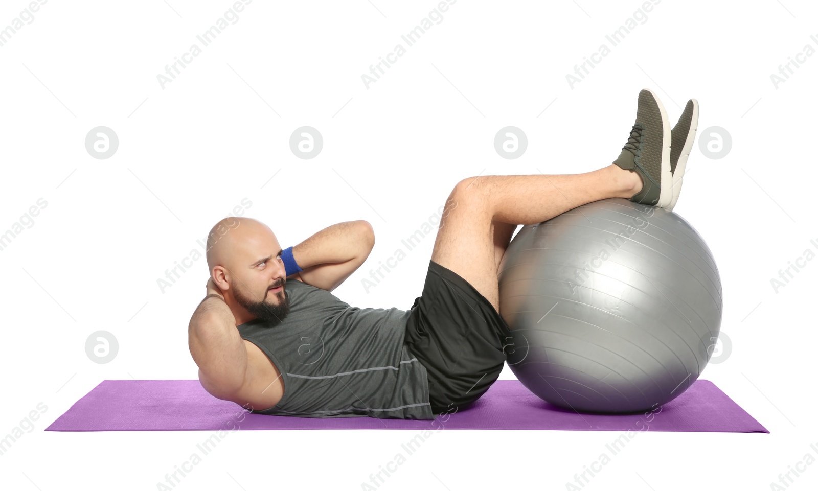 Photo of Overweight man doing exercise with fitness ball on white background