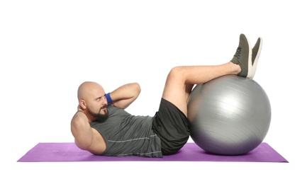 Overweight man doing exercise with fitness ball on white background