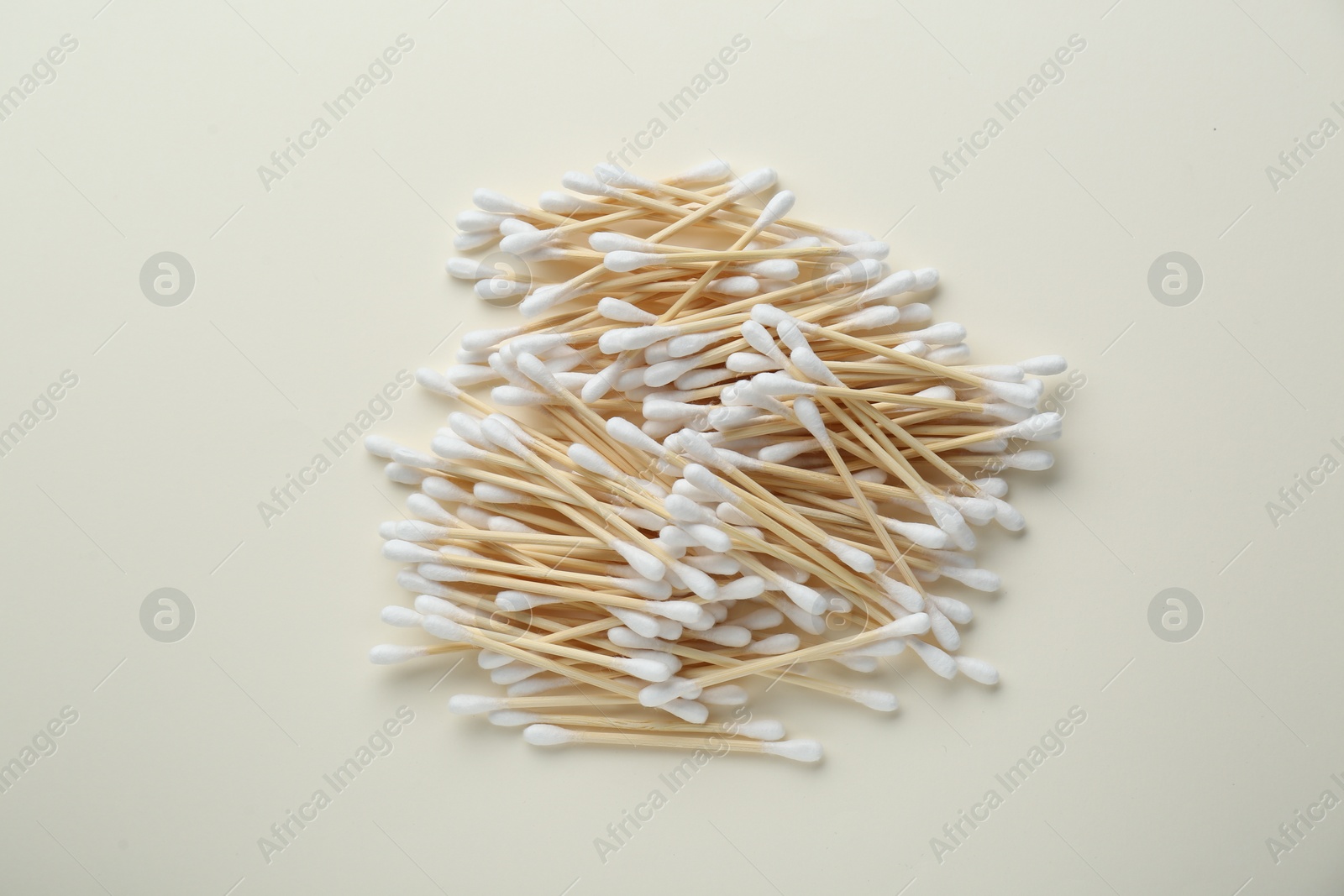 Photo of Heap of wooden cotton buds on beige background, flat lay