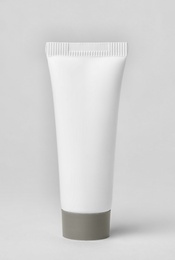 Photo of Tube of cosmetic product on light background
