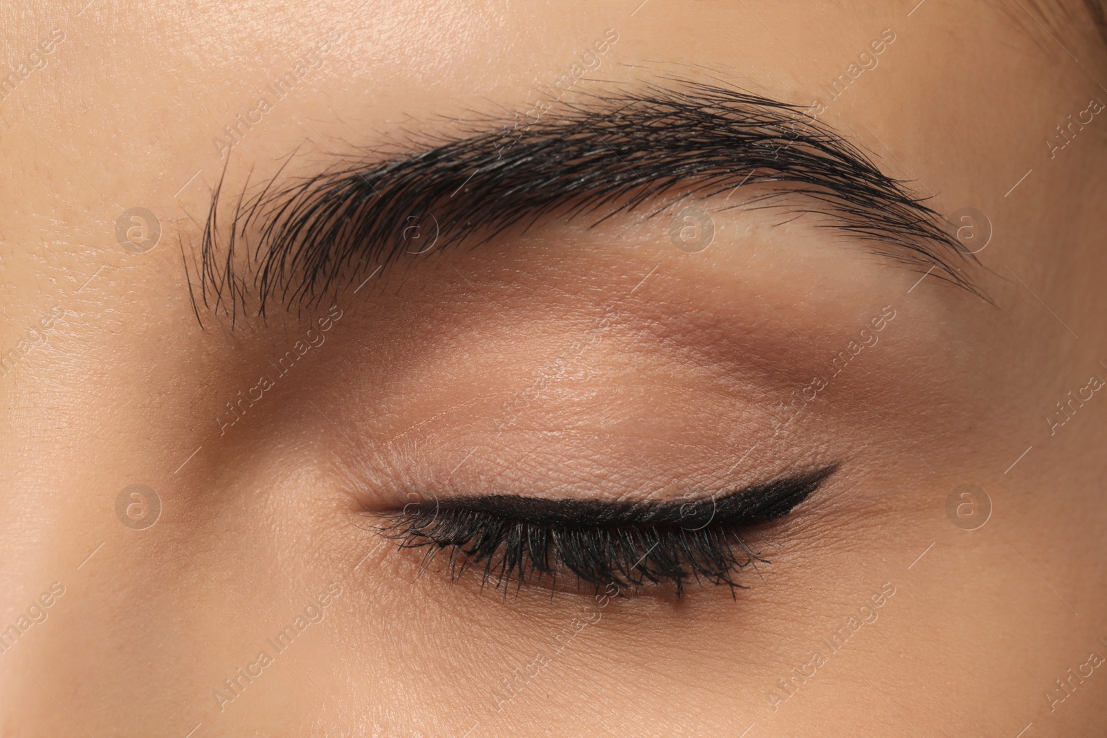 Photo of Young woman with permanent eyeliner makeup, closeup