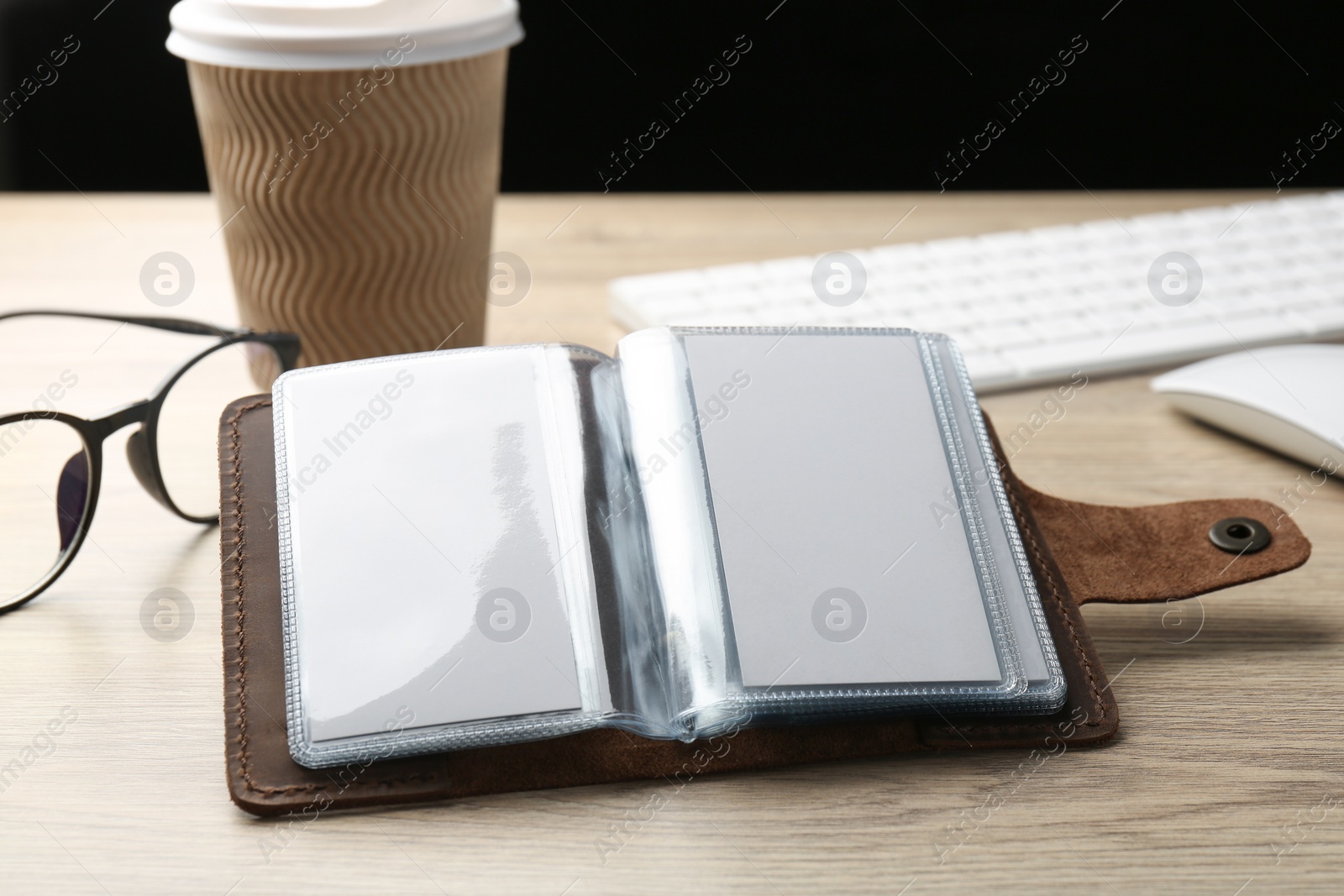 Photo of Leather business card holder with blank cards on wooden table