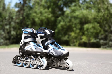 Photo of Modern inline roller skates in city park on sunny day
