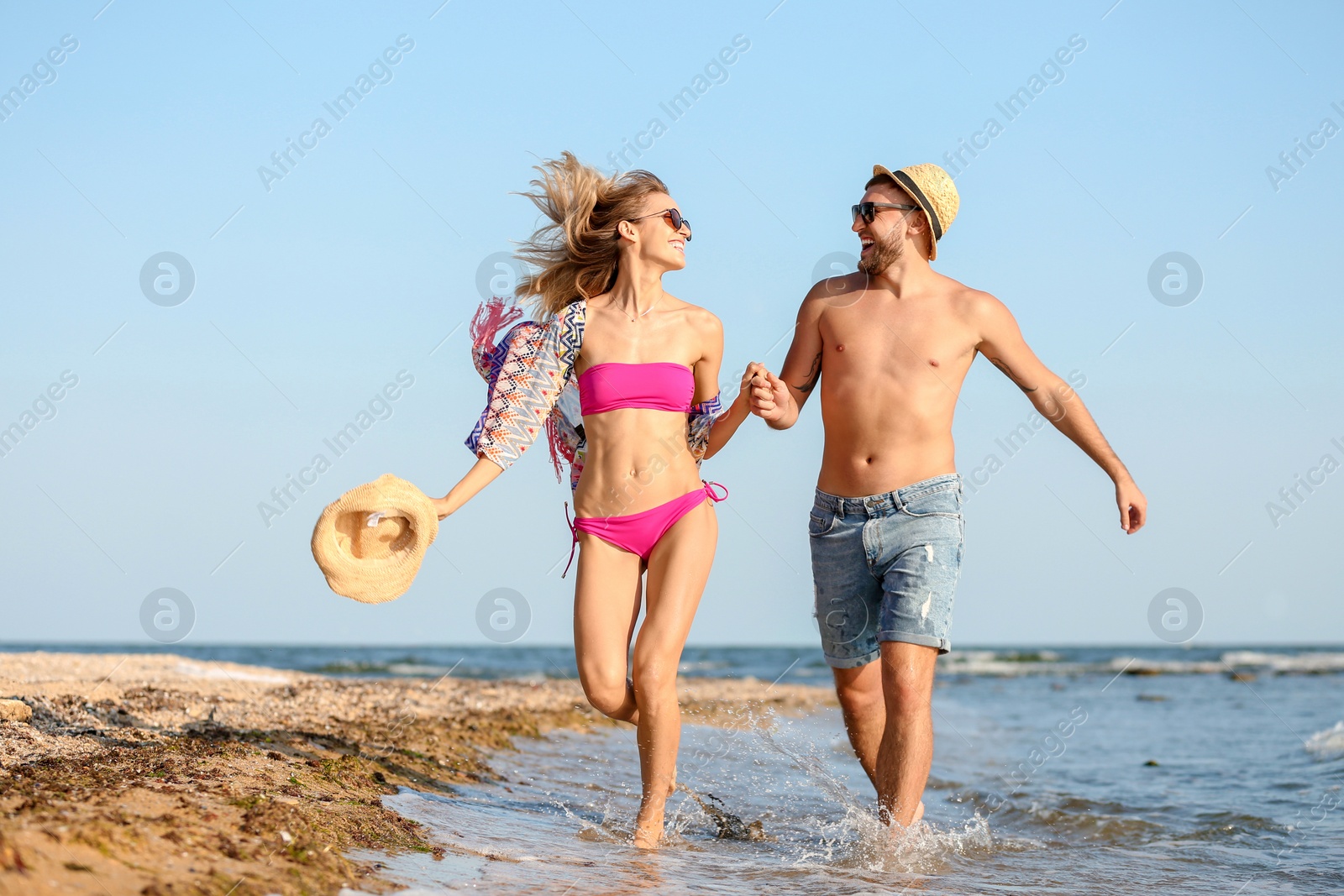 Photo of Young couple spending time together on beach