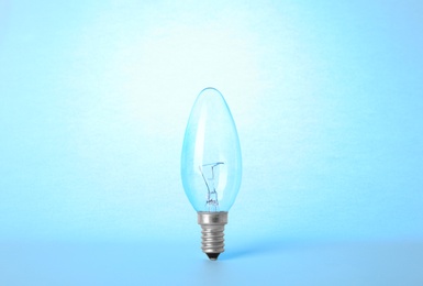 Photo of New modern lamp bulb on light blue background