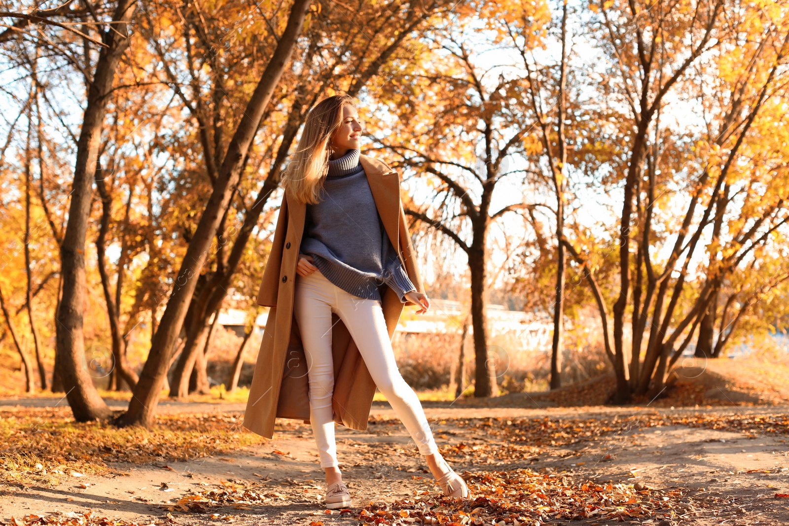 Photo of Beautiful young woman wearing stylish clothes in autumn park