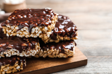 Photo of Delicious rice crispy treats on wooden table, closeup