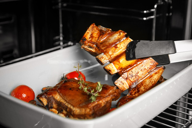 Photo of Delicious roasted ribs in oven, closeup. Yummy meat