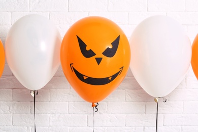 Photo of Color balloons for Halloween party against white brick wall