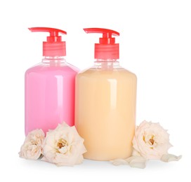 Dispensers with liquid soap and roses on white background