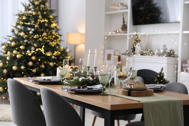 Christmas table setting with festive decor and dishware in living room