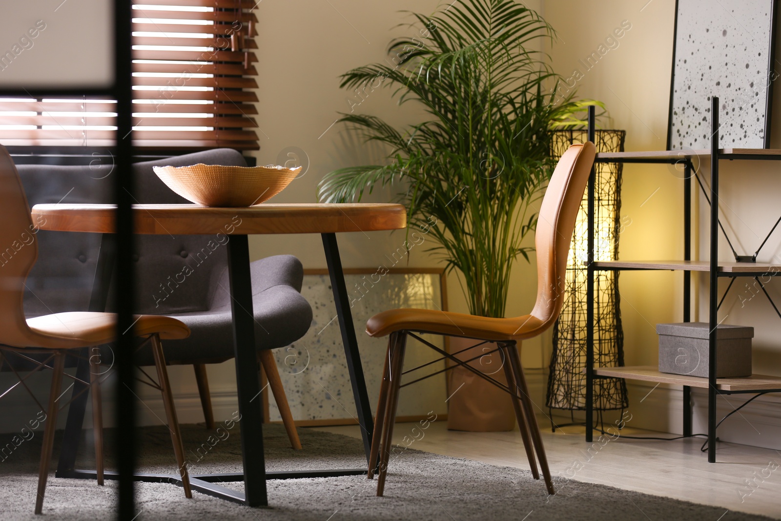 Photo of Stylish dining room interior with modern table set and window blinds