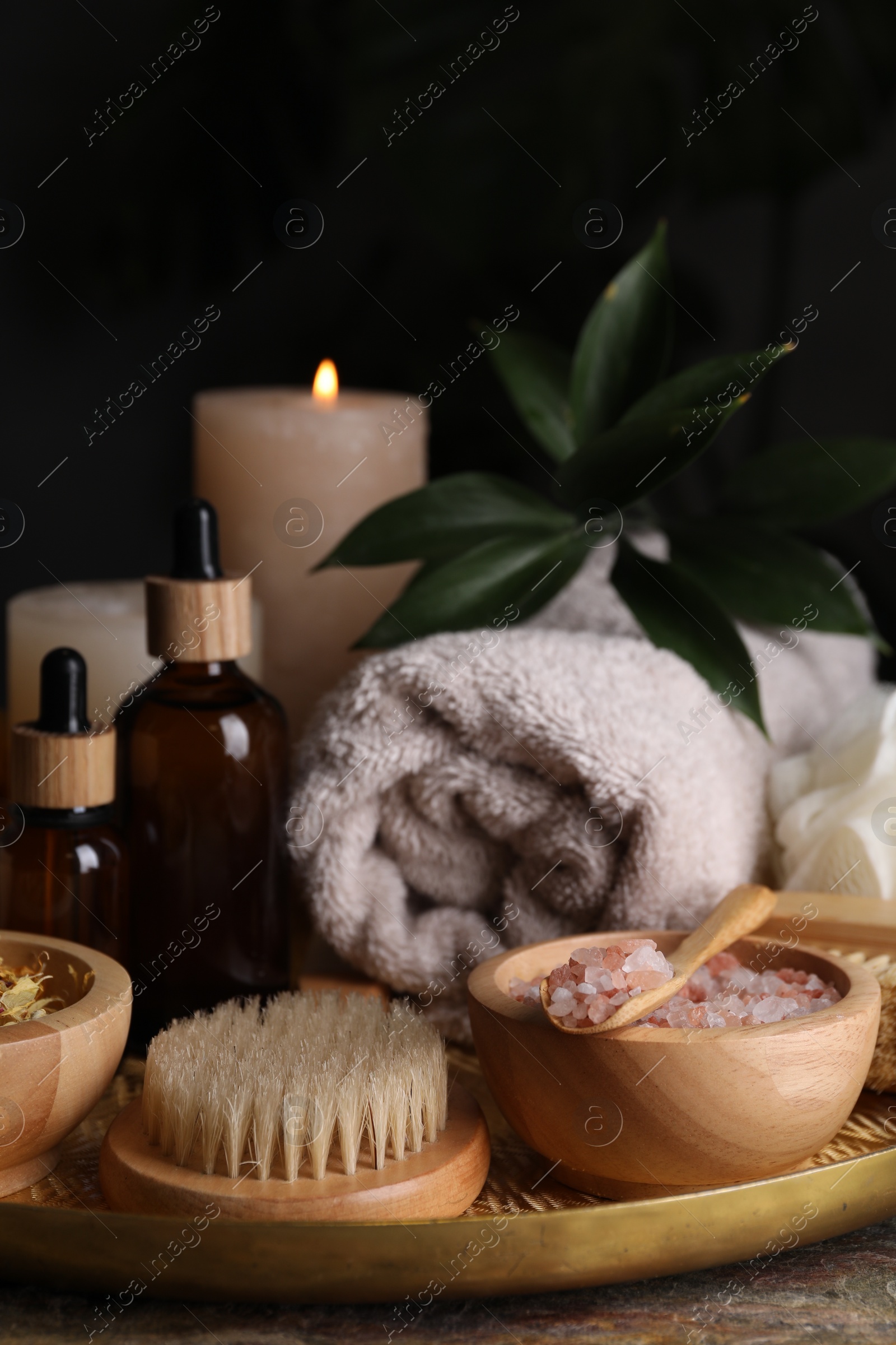 Photo of Spa composition. Pink sea salt, brush and bottles on table