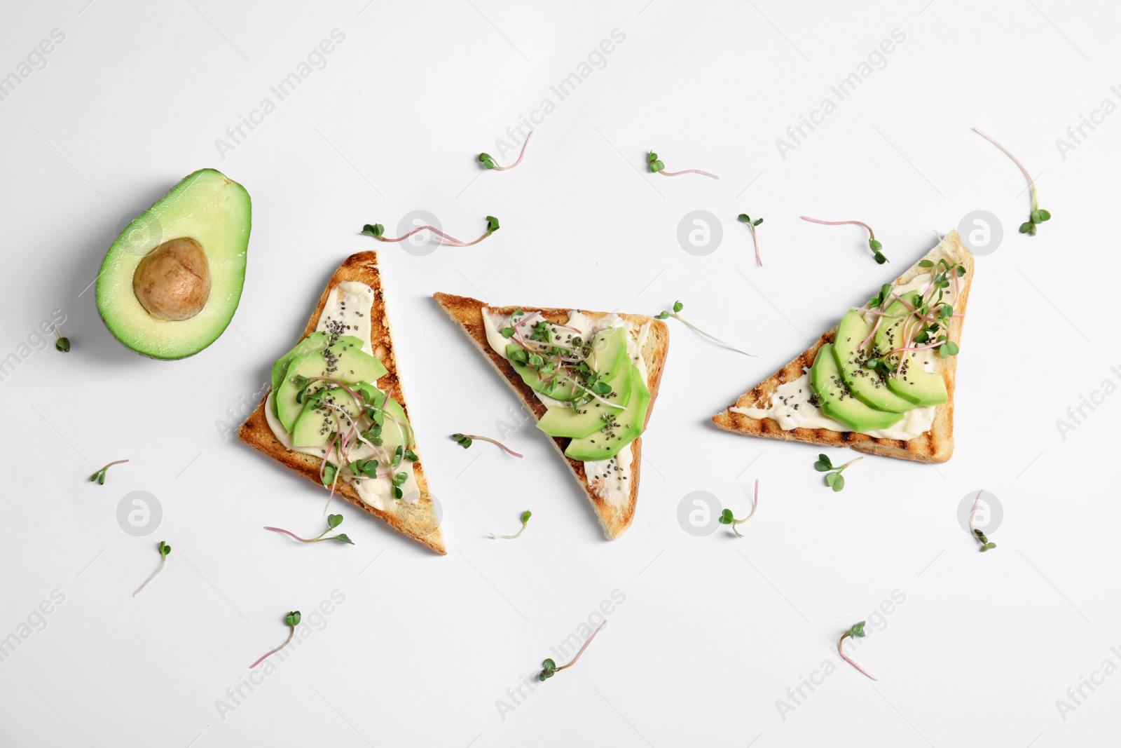 Photo of Tasty toasts with avocado, sprouts and chia seeds on white background, top view