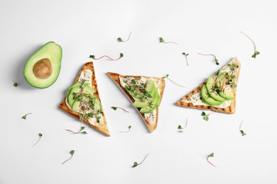 Photo of Tasty toasts with avocado, sprouts and chia seeds on white background, top view