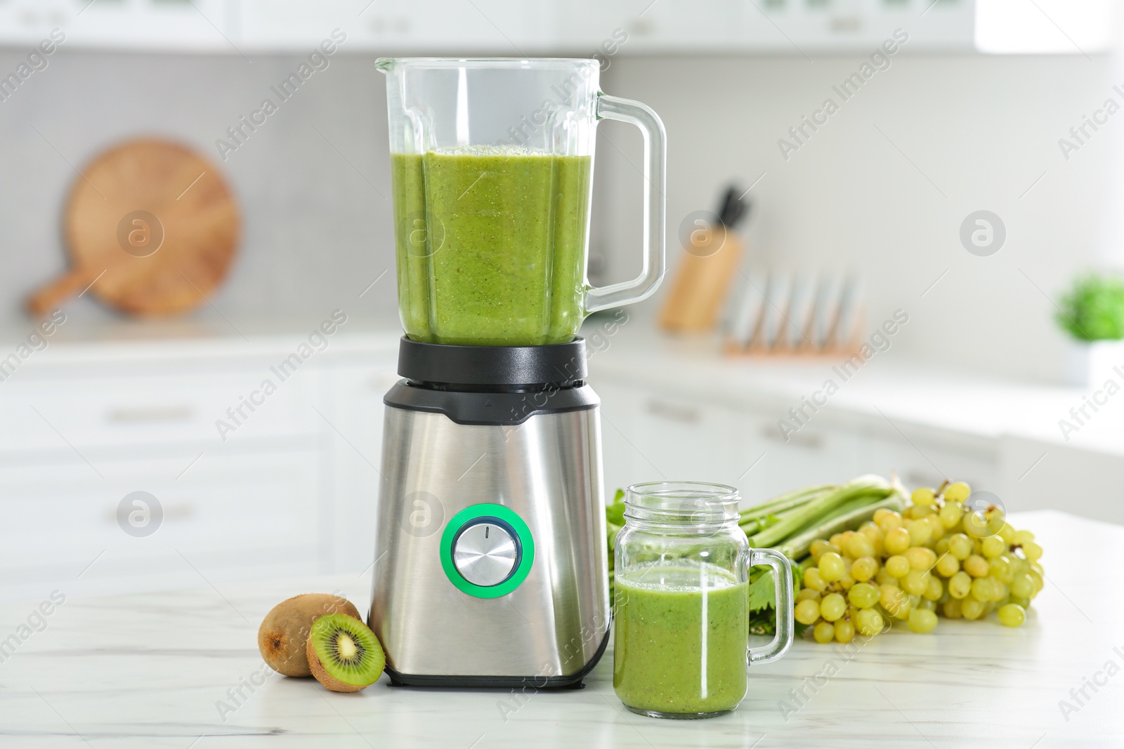 Photo of Delicious fresh smoothie and ingredients on white marble table in kitchen