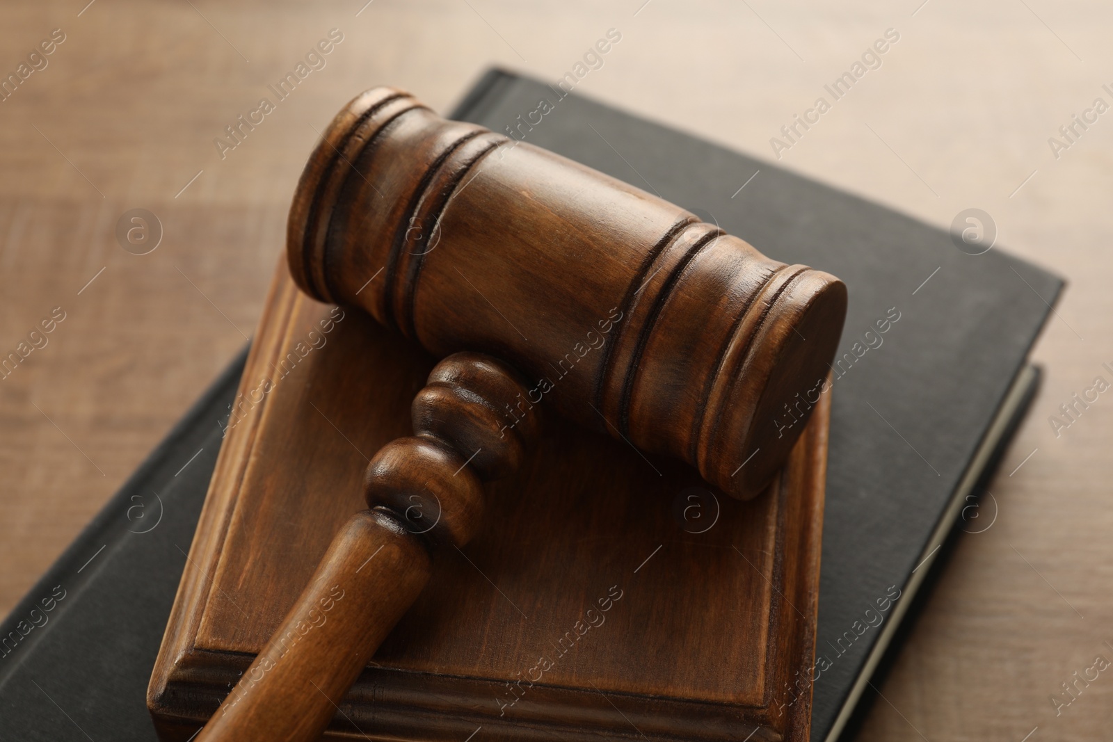 Photo of Law concept. Gavel and book on wooden table, closeup