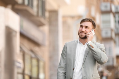 Portrait of young businessman talking on phone outdoors