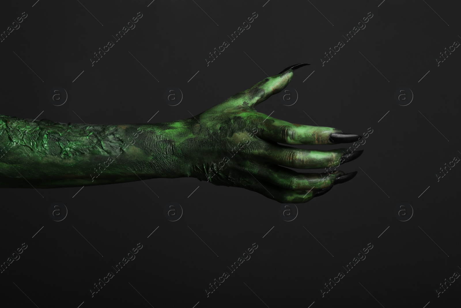 Photo of Scary monster on black background, closeup of hand. Halloween character