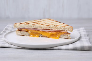 Photo of Delicious grilled sandwich with ham and cheese on light table