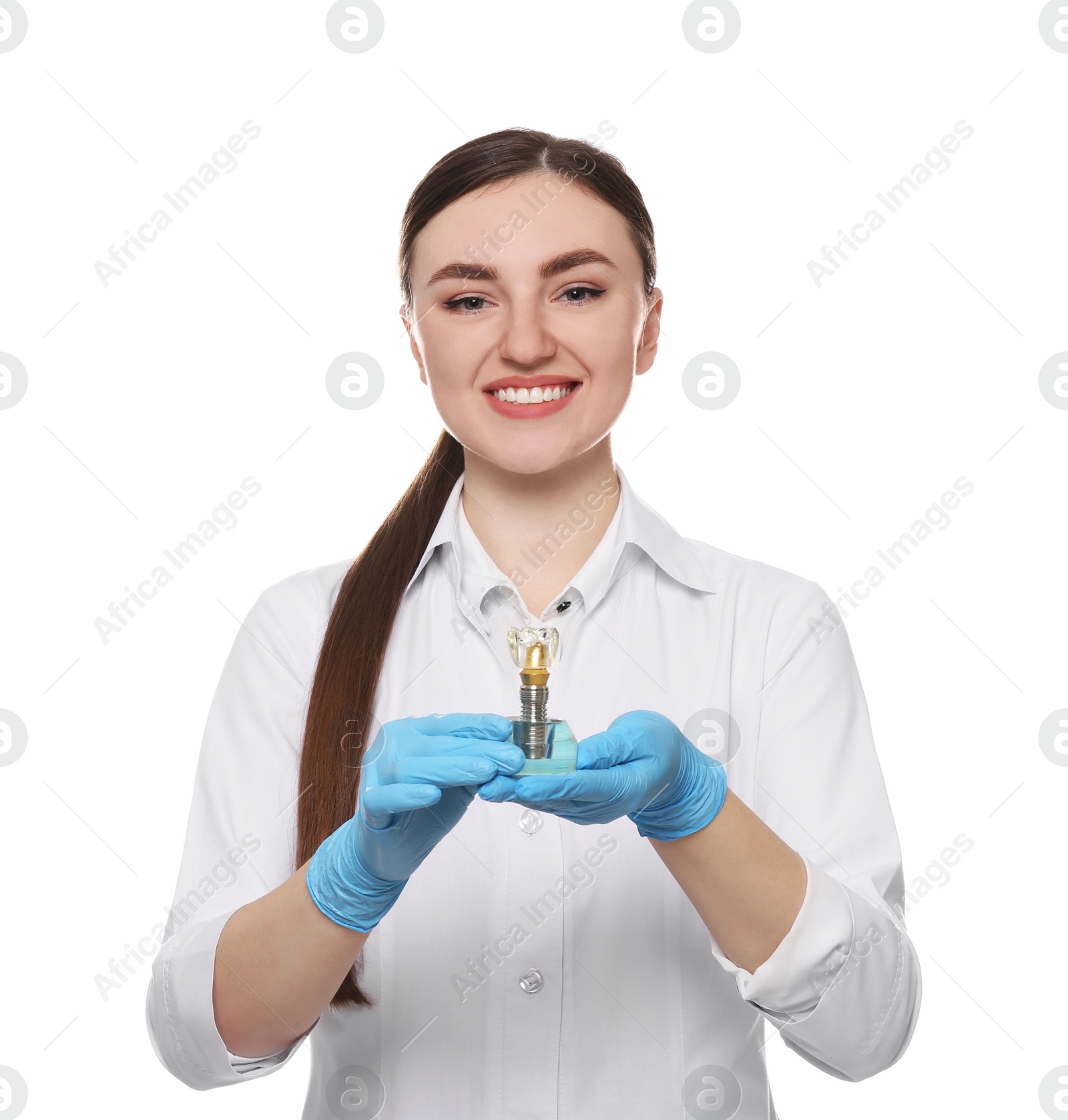 Photo of Dentist holding educational model of dental implant on white background