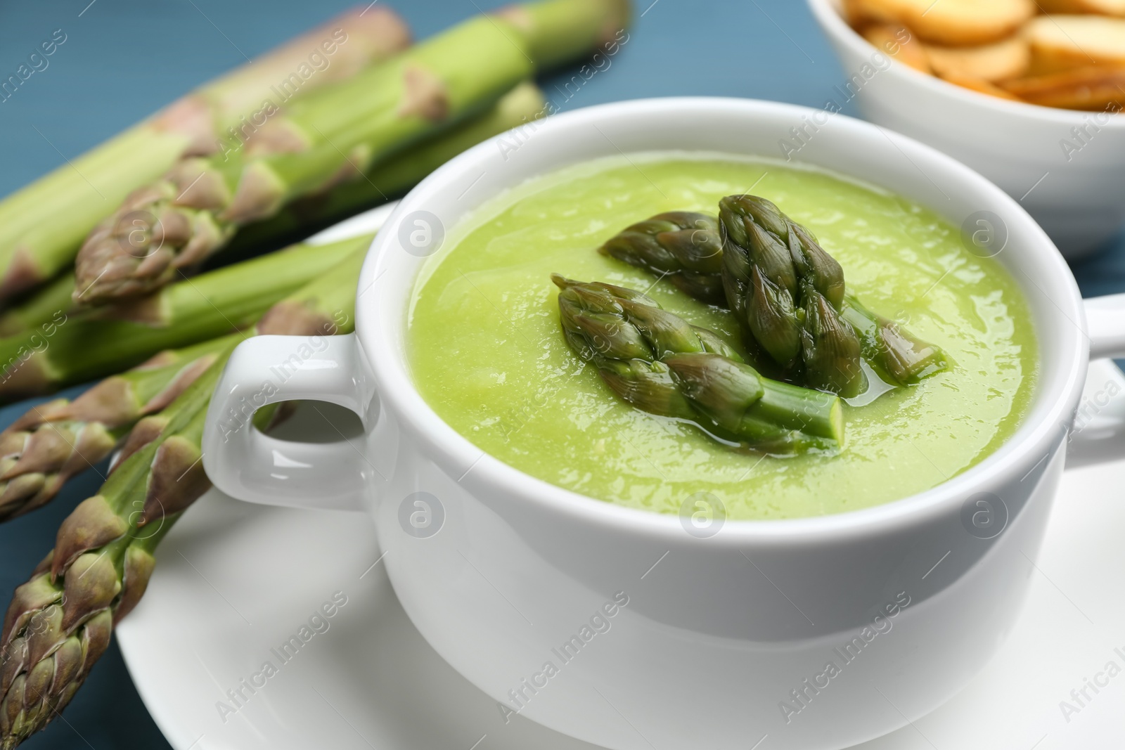 Photo of Delicious asparagus soup served in bowl, closeup