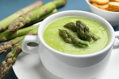Photo of Delicious asparagus soup served in bowl, closeup
