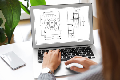 Image of Female engineer working with technical drawing on laptop indoors, closeup