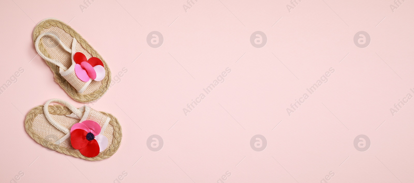 Image of Cute baby shoes on beige background, top view. Banner design with space for text