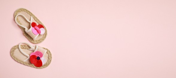 Image of Cute baby shoes on beige background, top view. Banner design with space for text